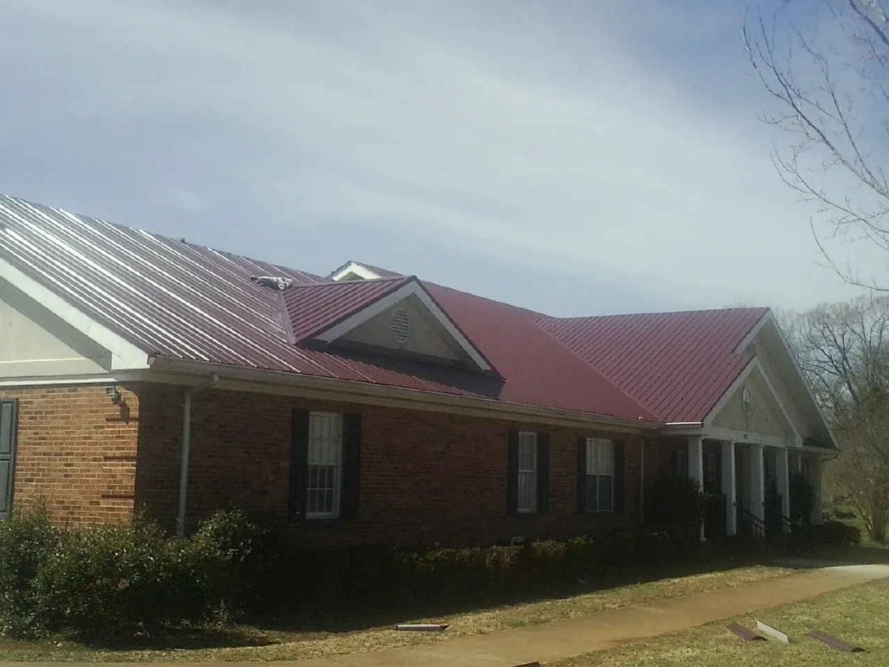 Red metal roof with gabled entries on a long brick building in Winfield